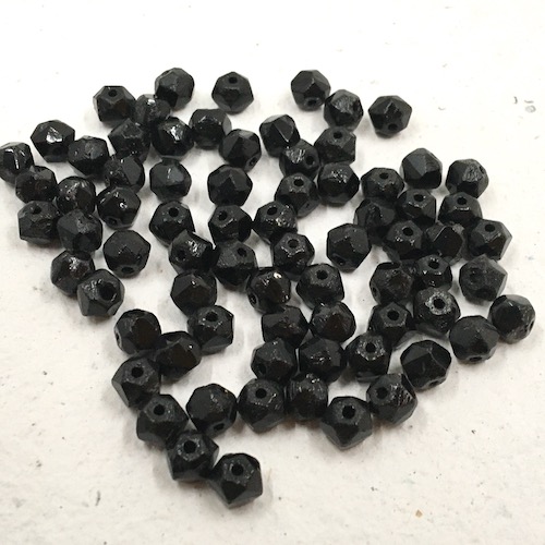 Small black glass beads with large diamond shaped facets