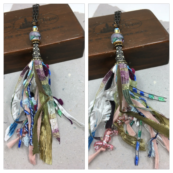 Necklace with lampwork bead, crystal, and crystal and metal tassel cap with tassel made of a variety of fibers. A second picture to the right shows the same necklace with the tassel spread out to reveal two of the pink dogs beads tied to the fiber.