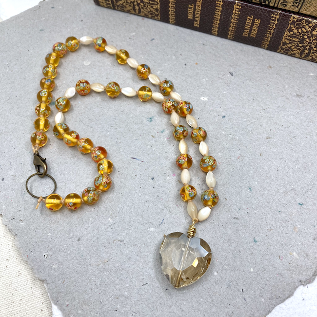 Necklace with yellow-grey crystal heart pendant, mother-of-pearl beads and vintage glass yellow beads with flowers. 