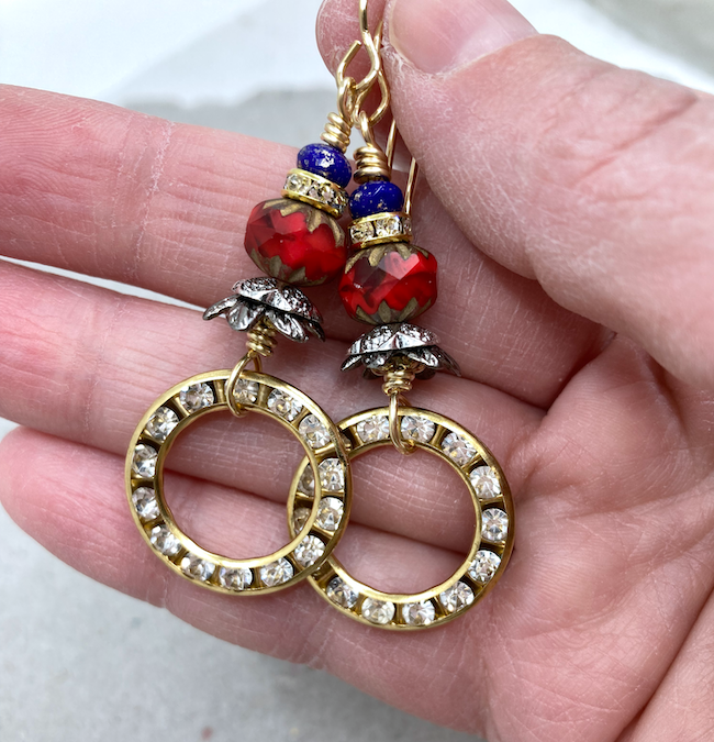 Earrings with hoops set with rhinestones and red and blue beads separated with rhinestone spacers. 