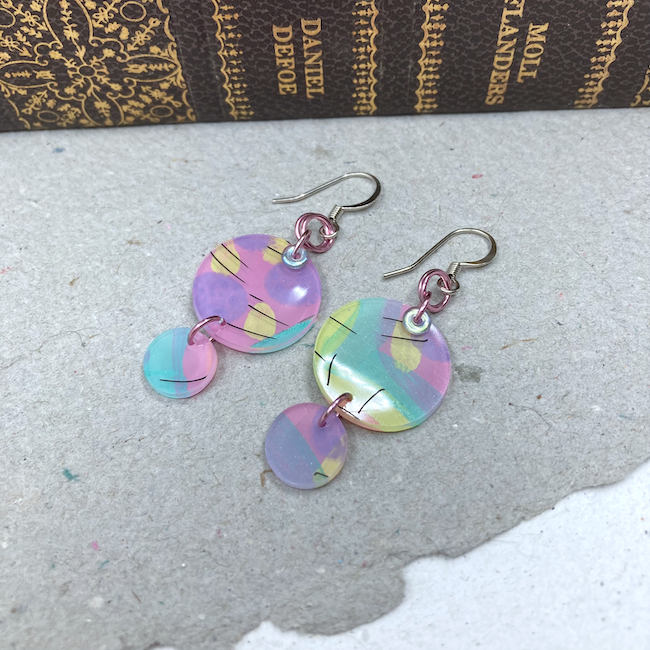 Earrings with pastel (purple, pink, yellow and blue-green) colors in two sizes of rounds. 